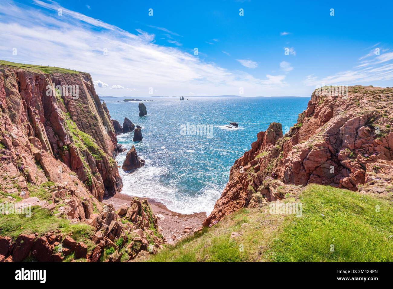 Regno Unito, Scozia, scogliere di Northmavine con le pile di mare di Drongs sullo sfondo Foto Stock