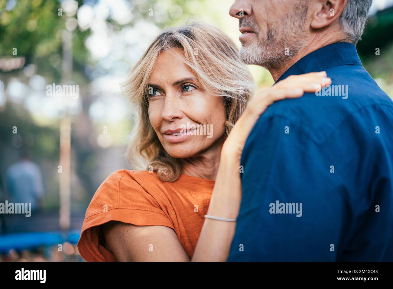 Donna sorridente in piedi con l'uomo nel cortile posteriore Foto Stock
