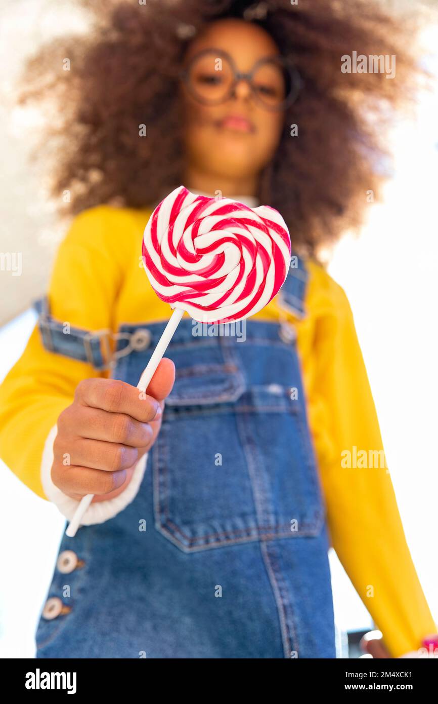Ragazza che tiene lollipop con morso mancante Foto Stock