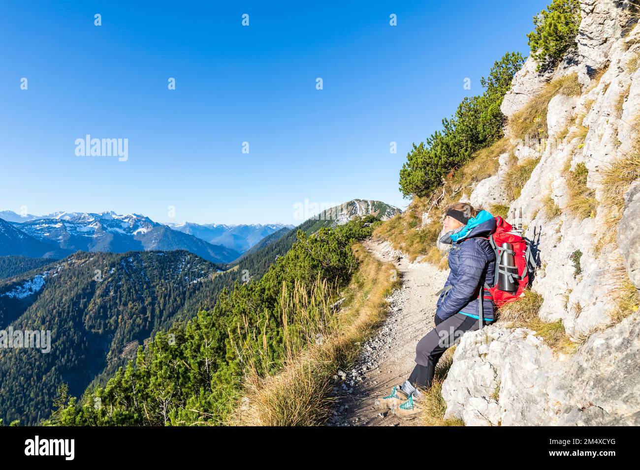 Germania, Baviera, escursionista femminile in pausa lungo il sentiero che conduce alla cima del monte Heimgarten Foto Stock