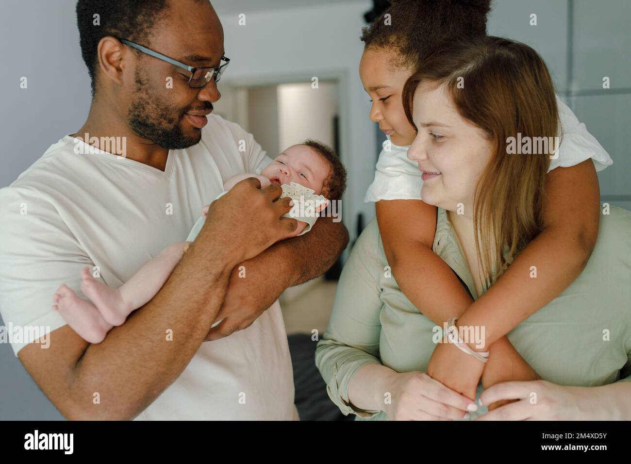 Felice padre e madre che trascorrono il tempo con le figlie a casa Foto Stock