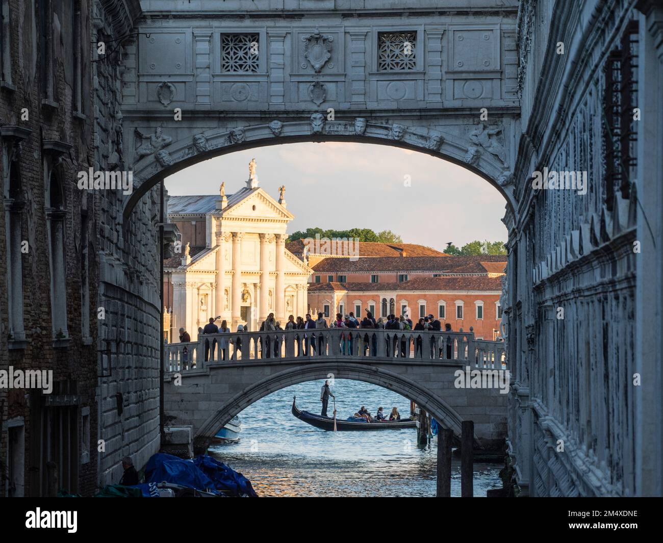La Chiesa del Redentore si vede attraverso il Ponte dei Sospiri, passando sotto la gondola, Venezia, Italia Foto Stock