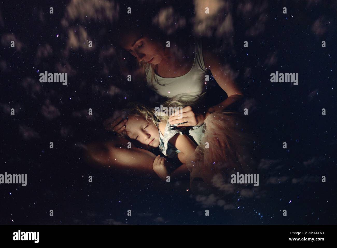 Madre di fronte alla figlia addormentata di notte Foto Stock