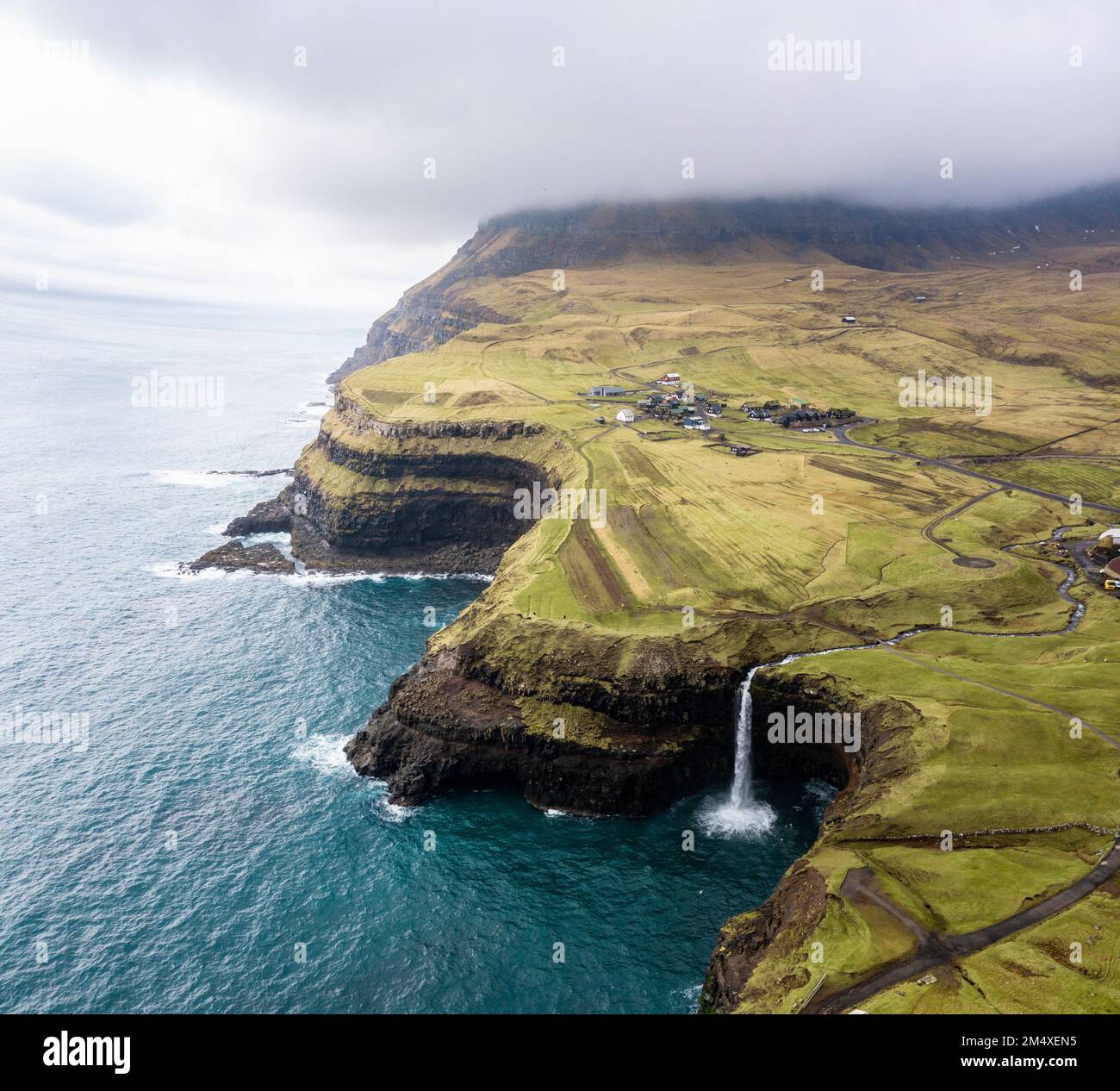 Vista panoramica della cascata di Mulafossur con montagna e mare Foto Stock