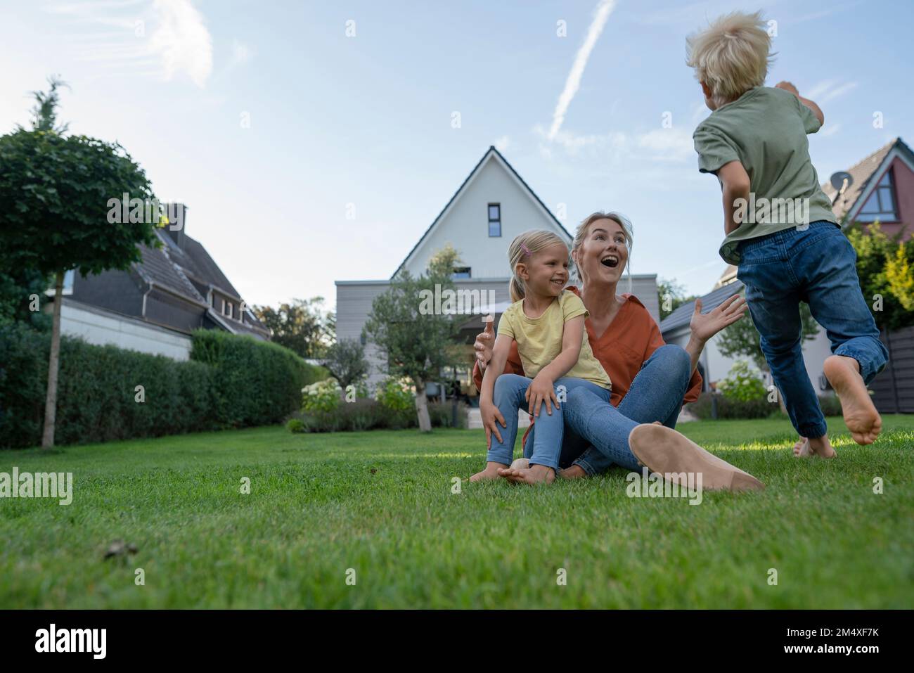Felice donna godendo con i bambini in giardino Foto Stock