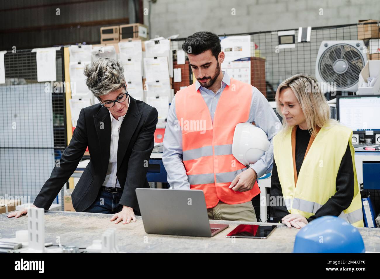 Progettare con i colleghi che discutono di laptop nel settore Foto Stock