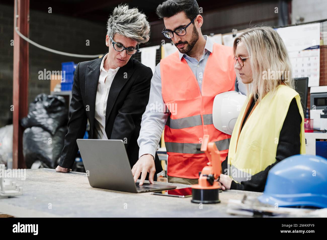 Progettare con i colleghi che discutono di laptop nel settore Foto Stock