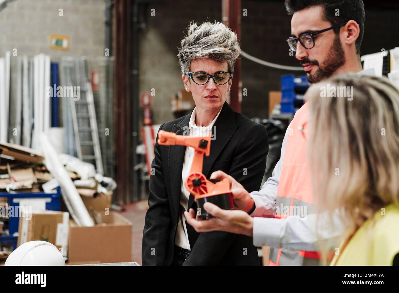 Gli ingegneri discutono del braccio robotico nell'industria Foto Stock