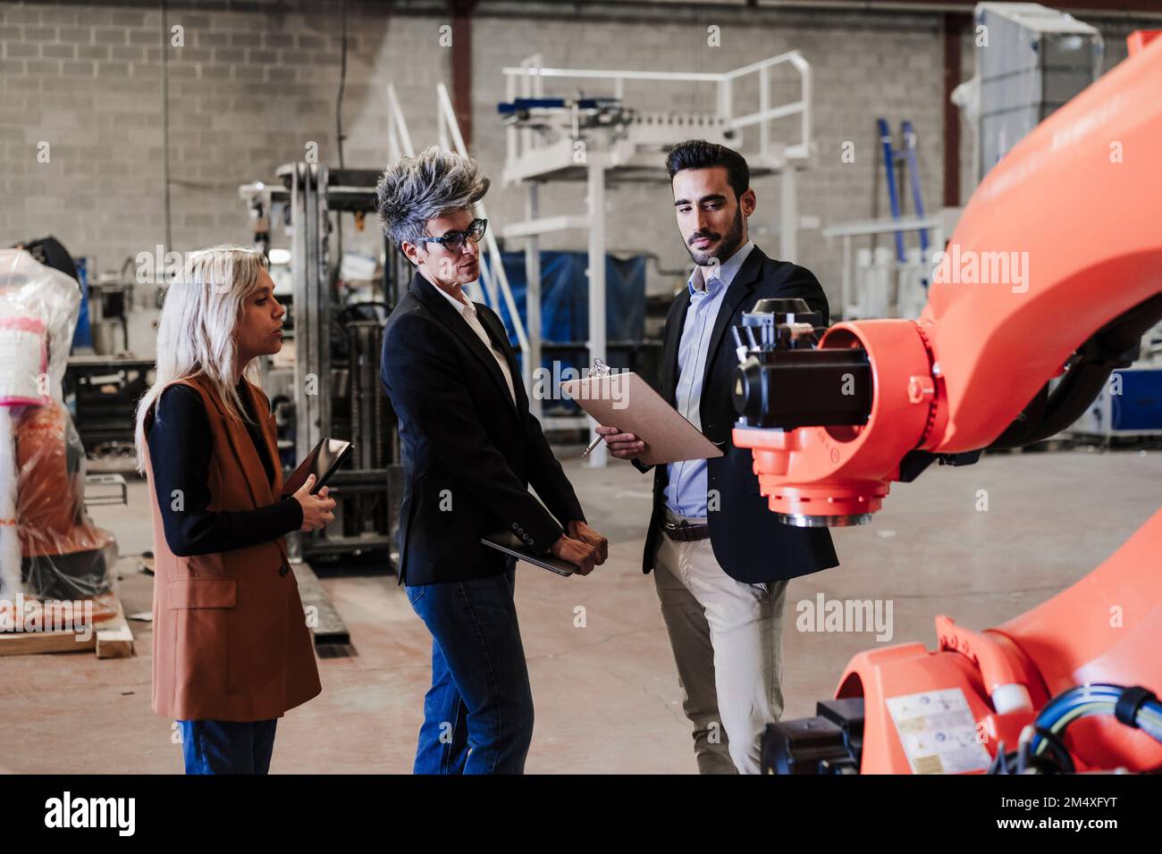 Gli ingegneri discutono del braccio robotico nell'industria Foto Stock