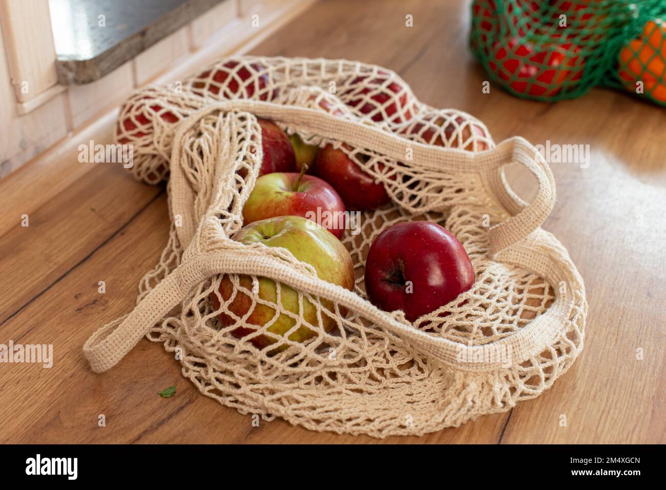 Mele in un sacchetto di maglia sul bancone della cucina Foto Stock