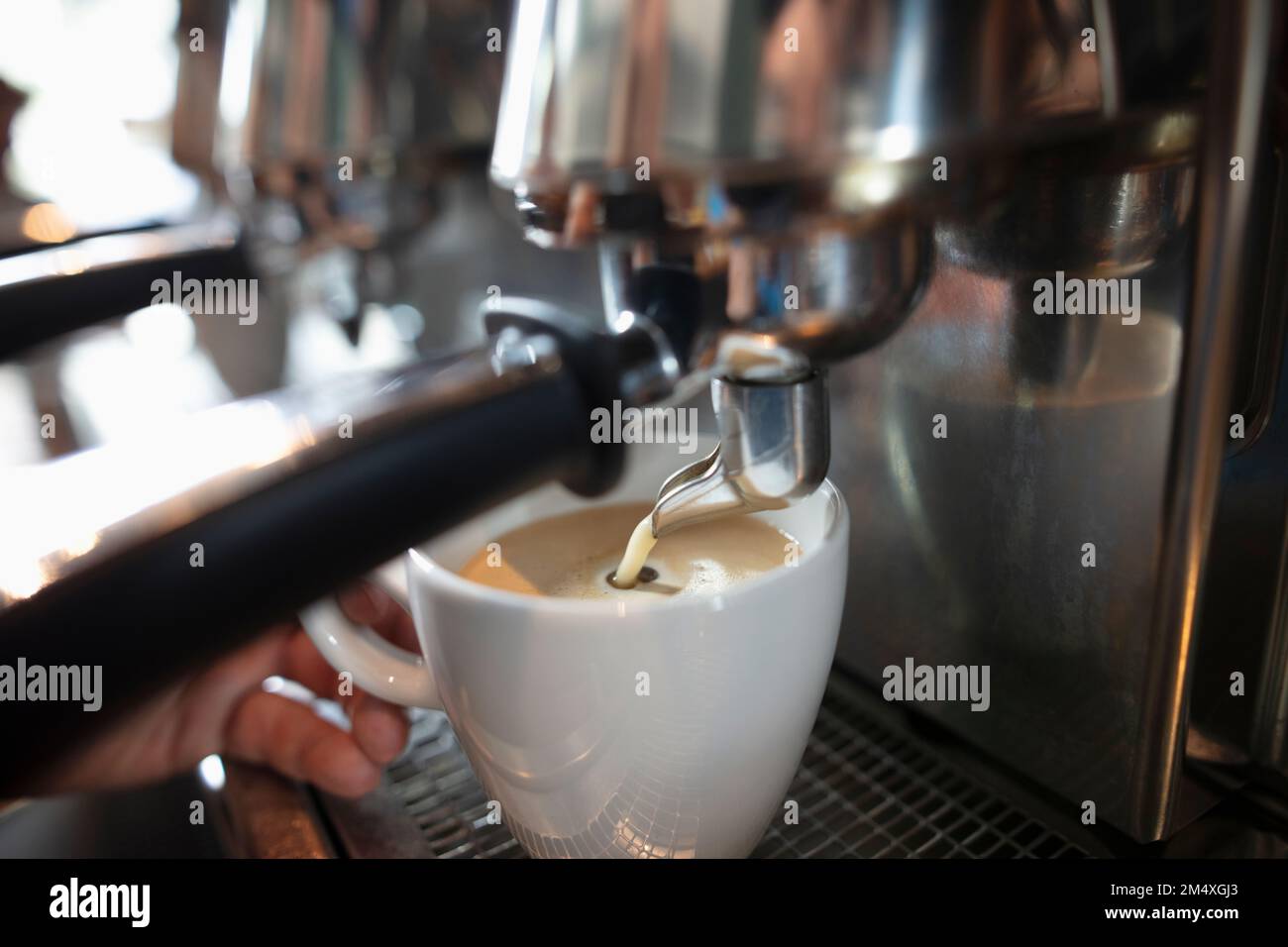Una tazza bianca sotto la macchina del caffè Foto stock - Alamy