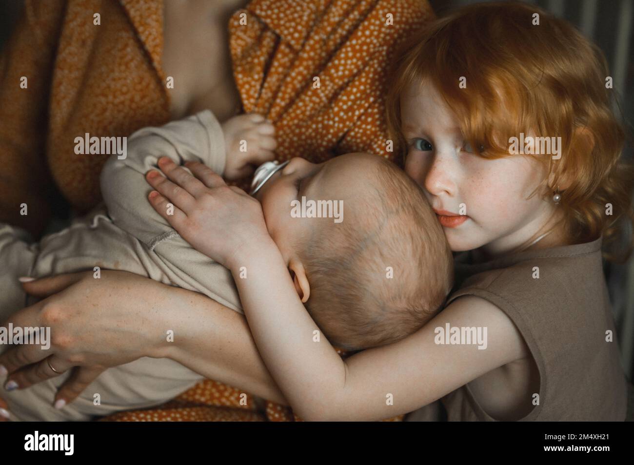 Madre con figlia che abbraccia la bambina a casa Foto Stock