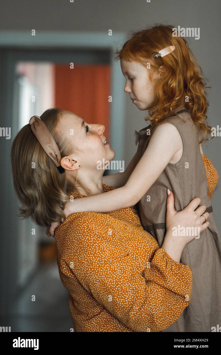 Madre felice che gioca e abbraccia figlia a casa Foto Stock