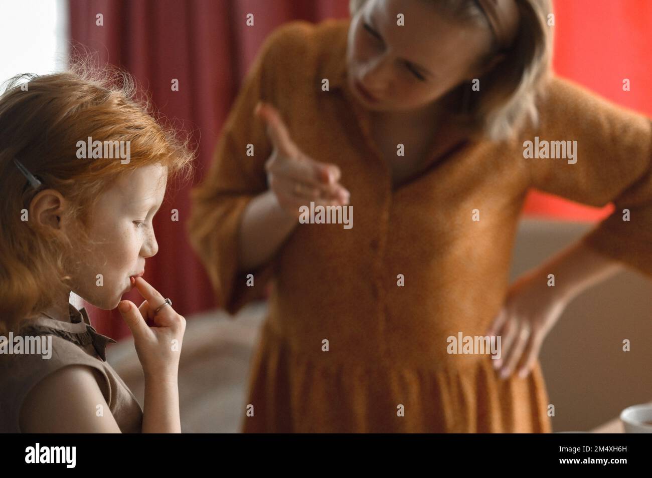 Madre che scola figlia a casa Foto Stock