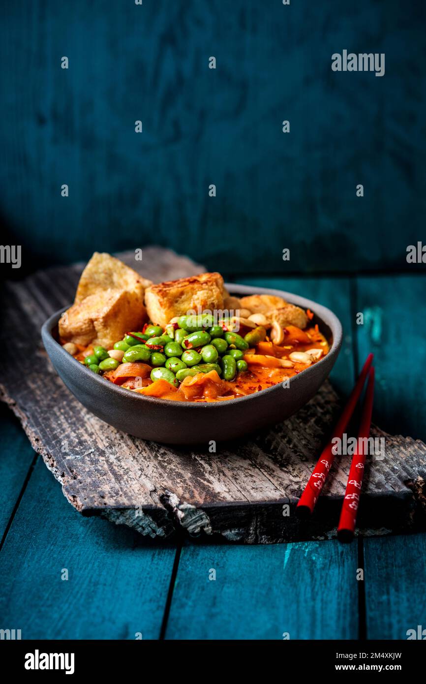 Ciotola di curry vegano pronto a mangiare con edamame e tofu Foto Stock