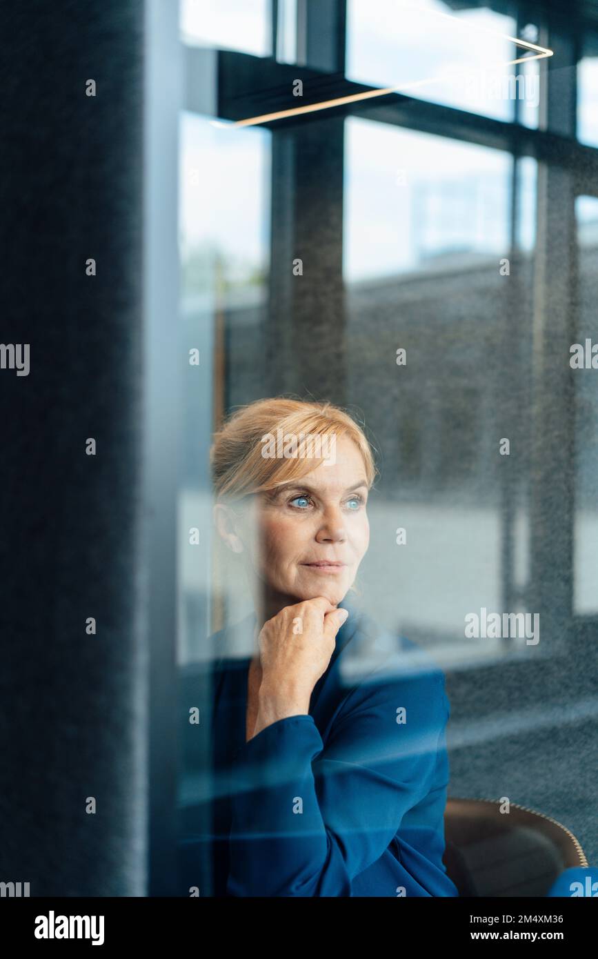 Donna d'affari premurosa in cabina insonorizzata sul posto di lavoro Foto Stock