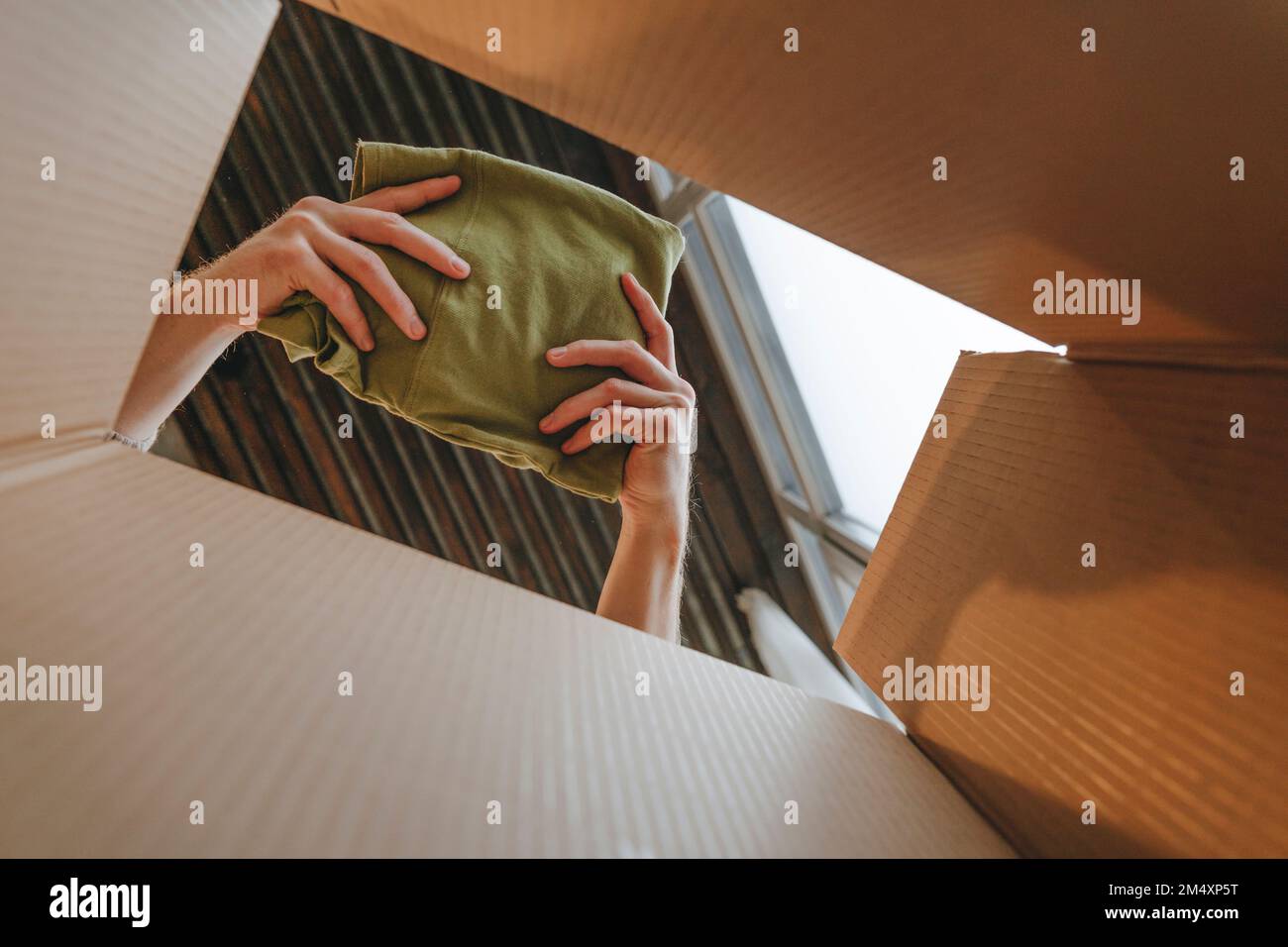 Mani del panno da imballaggio stilista in scatola di cartone Foto Stock