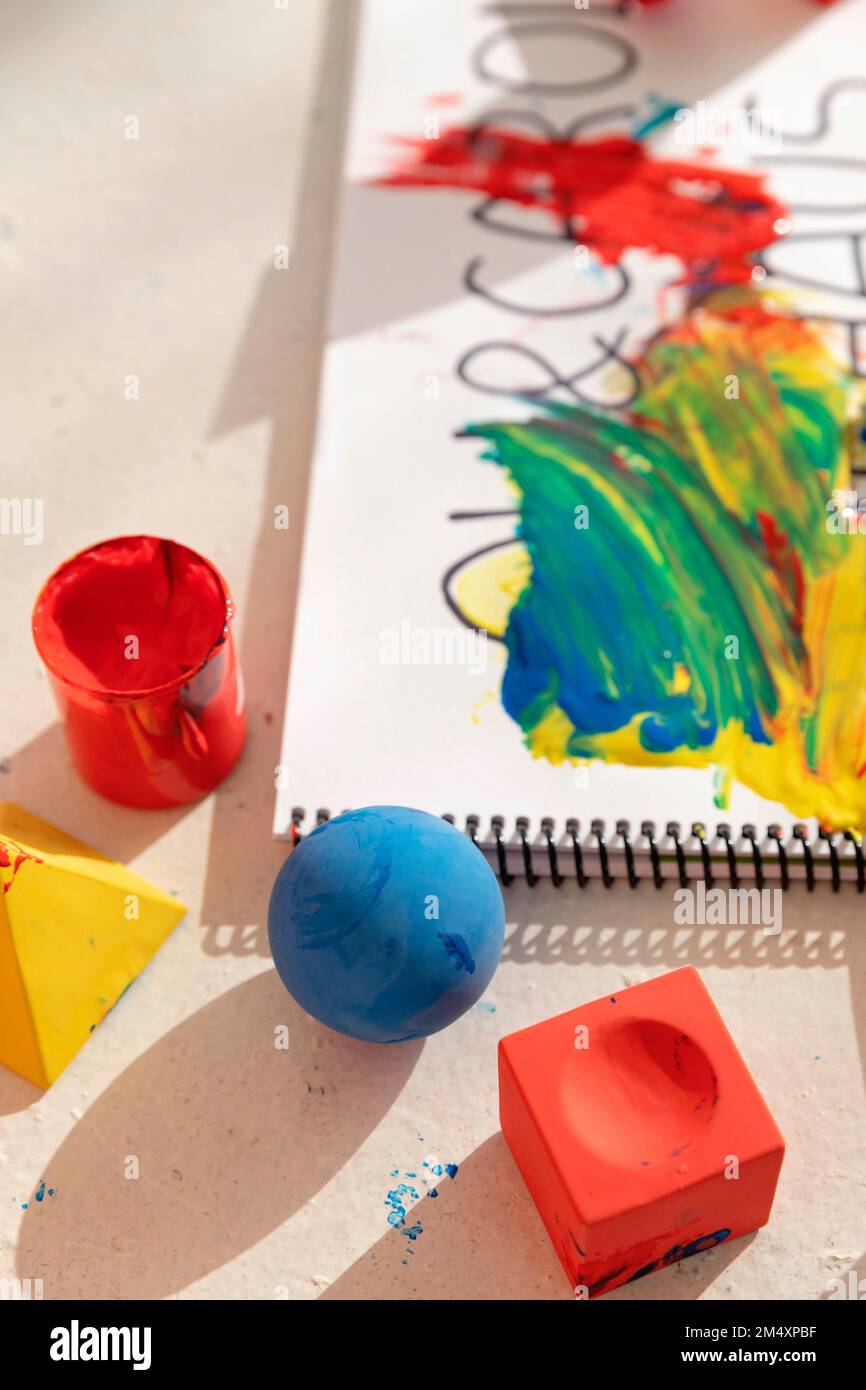 Blocchi di giocattoli colorati e blocco note ricoperti di vernice Foto Stock
