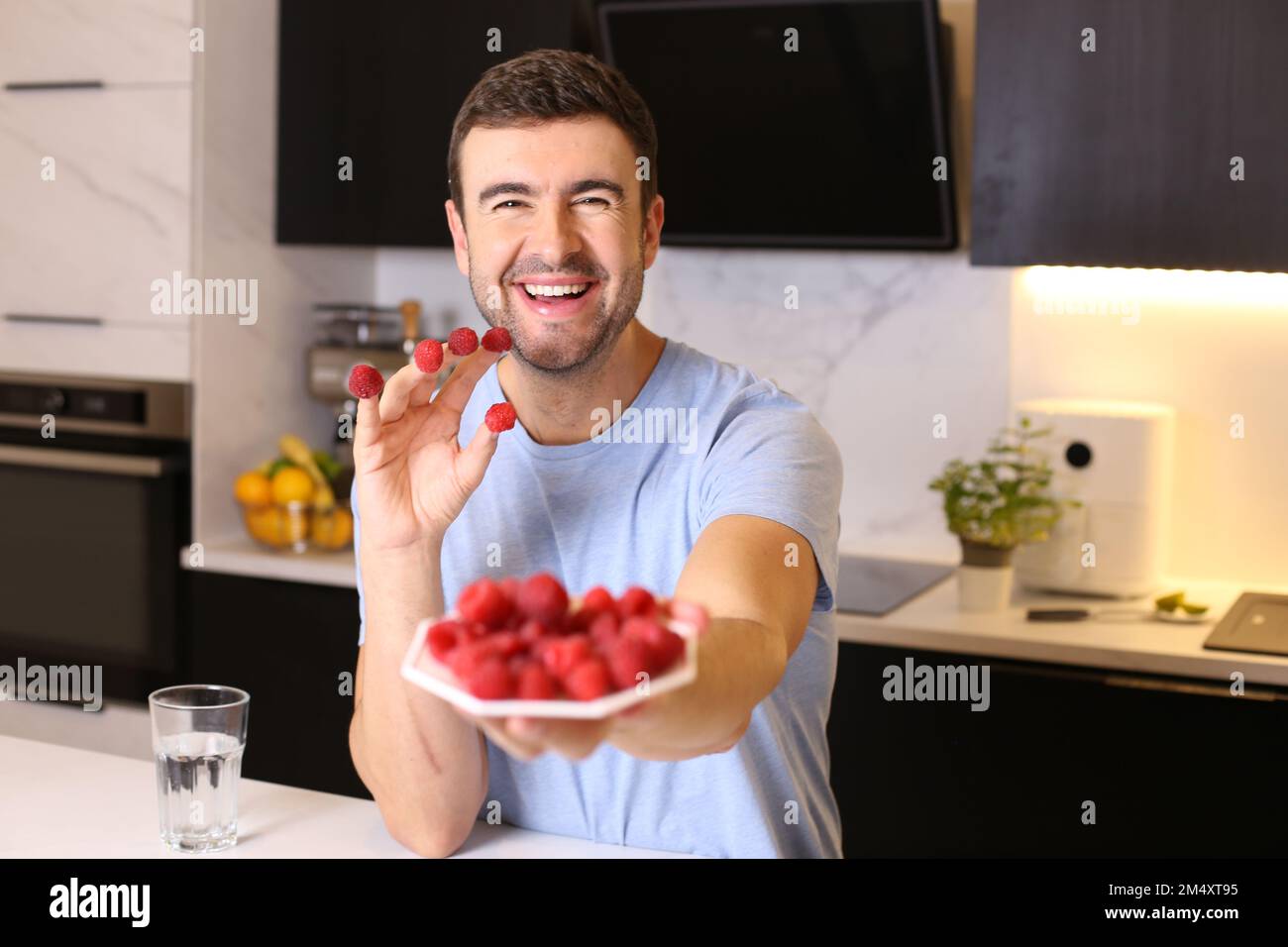 Uomo che gode di un piatto di framboise fresco Foto Stock