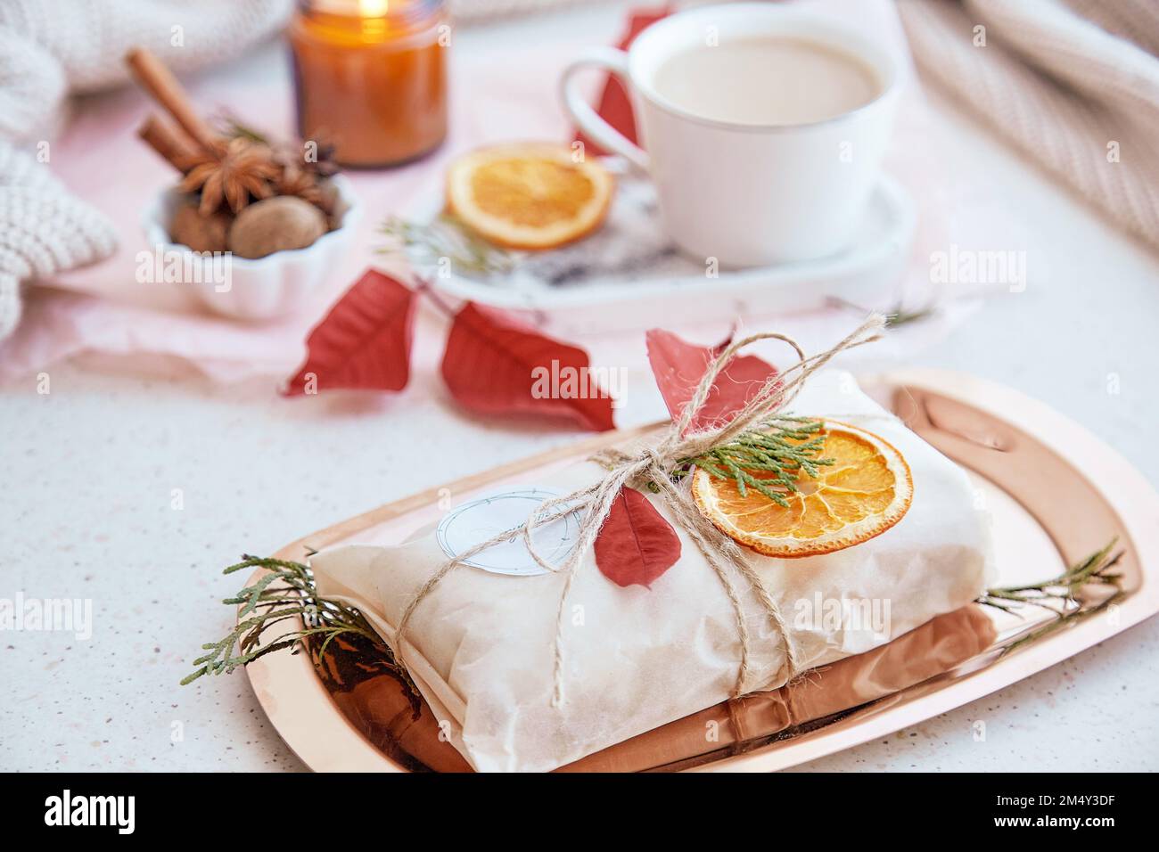 Torta tradizionale tedesca decorata in omaggio, tazza di cacao, arance secche e candela. Regalo per la stagione natalizia. Estetica accogliente casa. Foto Stock