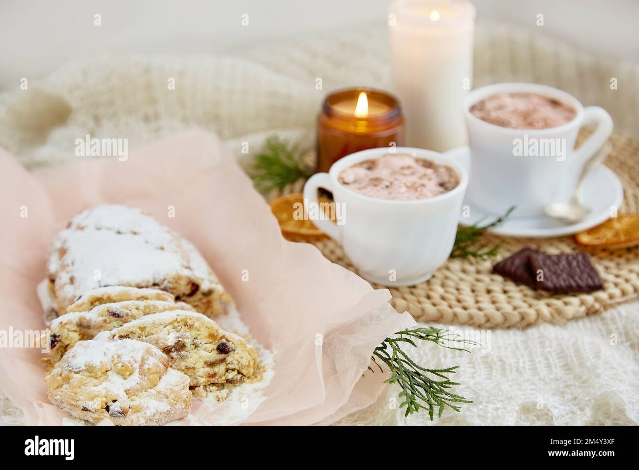 Tradizionale stollen di Natale e tazze di caffè, candele e decorazioni invernali - accogliente casa di Natale. Stagione di festa, dolce dolce. Foto Stock