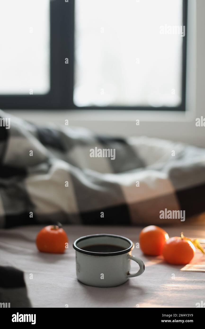 Inverno concetto accogliente. Tazza con caffè e mandarini sul letto. Spazio di copia. Piano di giacitura, vista dall'alto Foto Stock