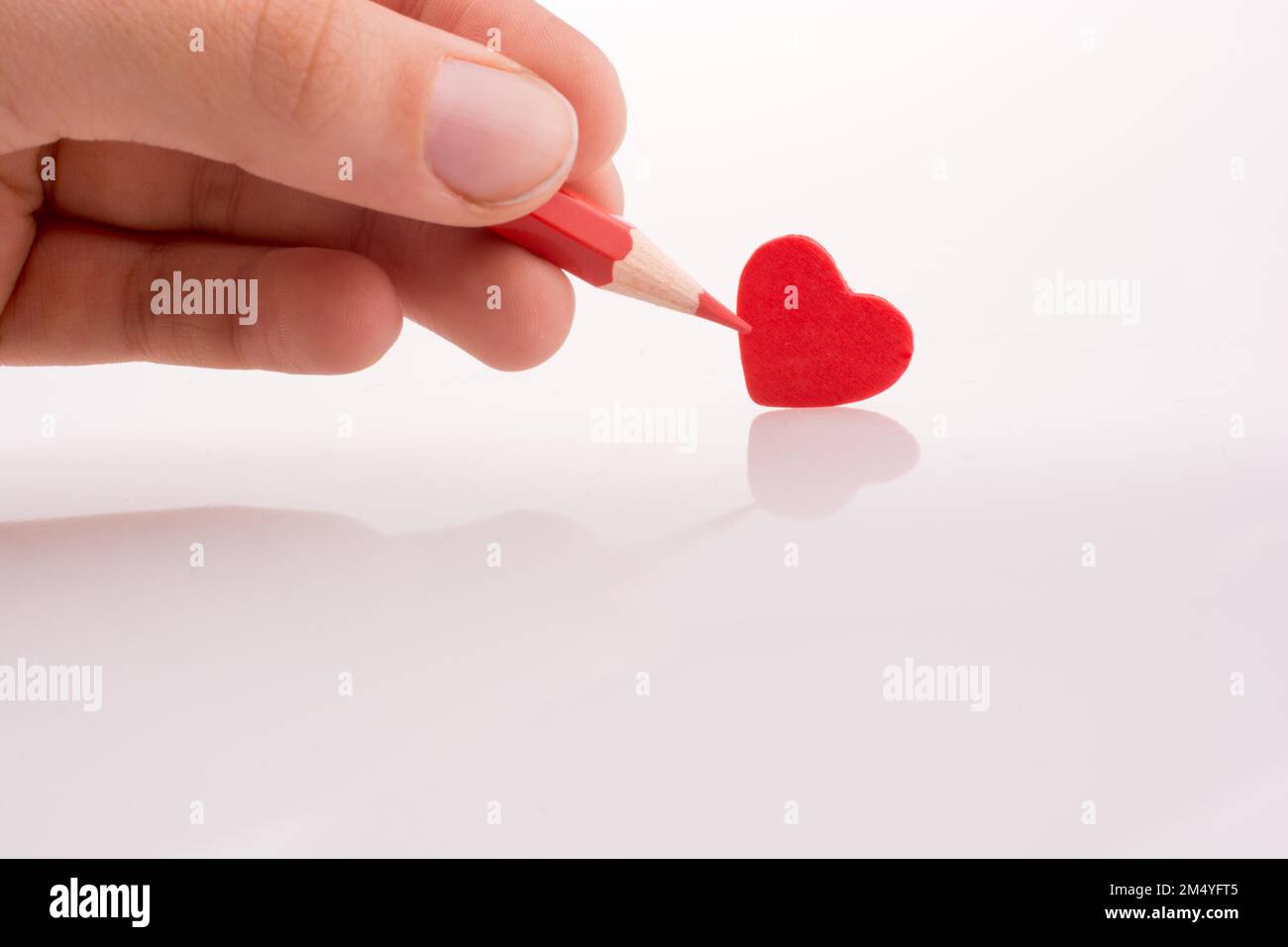 Puntamento a matita un cuore rosso Foto Stock