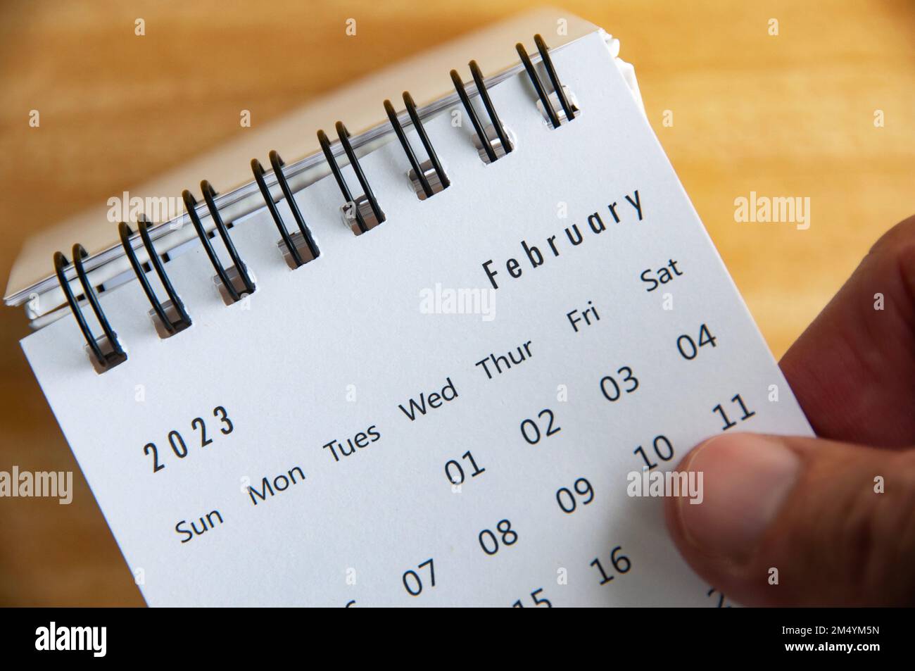 Febbraio 2023 calendario da tavolo bianco con sfondo da tavolo in legno. Calendario e nuovo mese 2023. Foto Stock