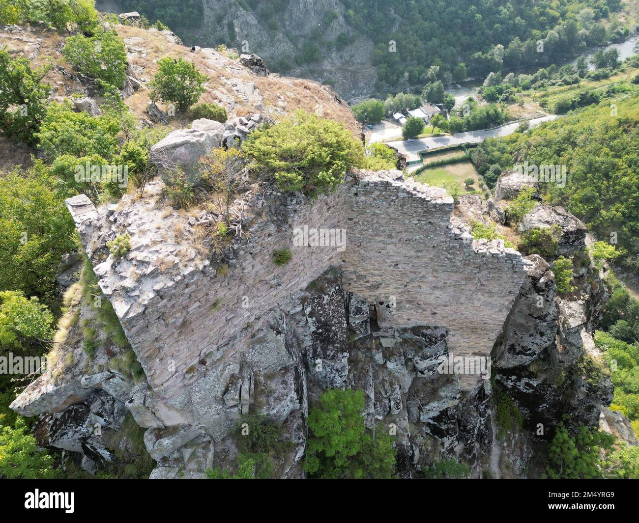 Una vista dall'alto di antiche rovine su una montagna boschiva Foto Stock