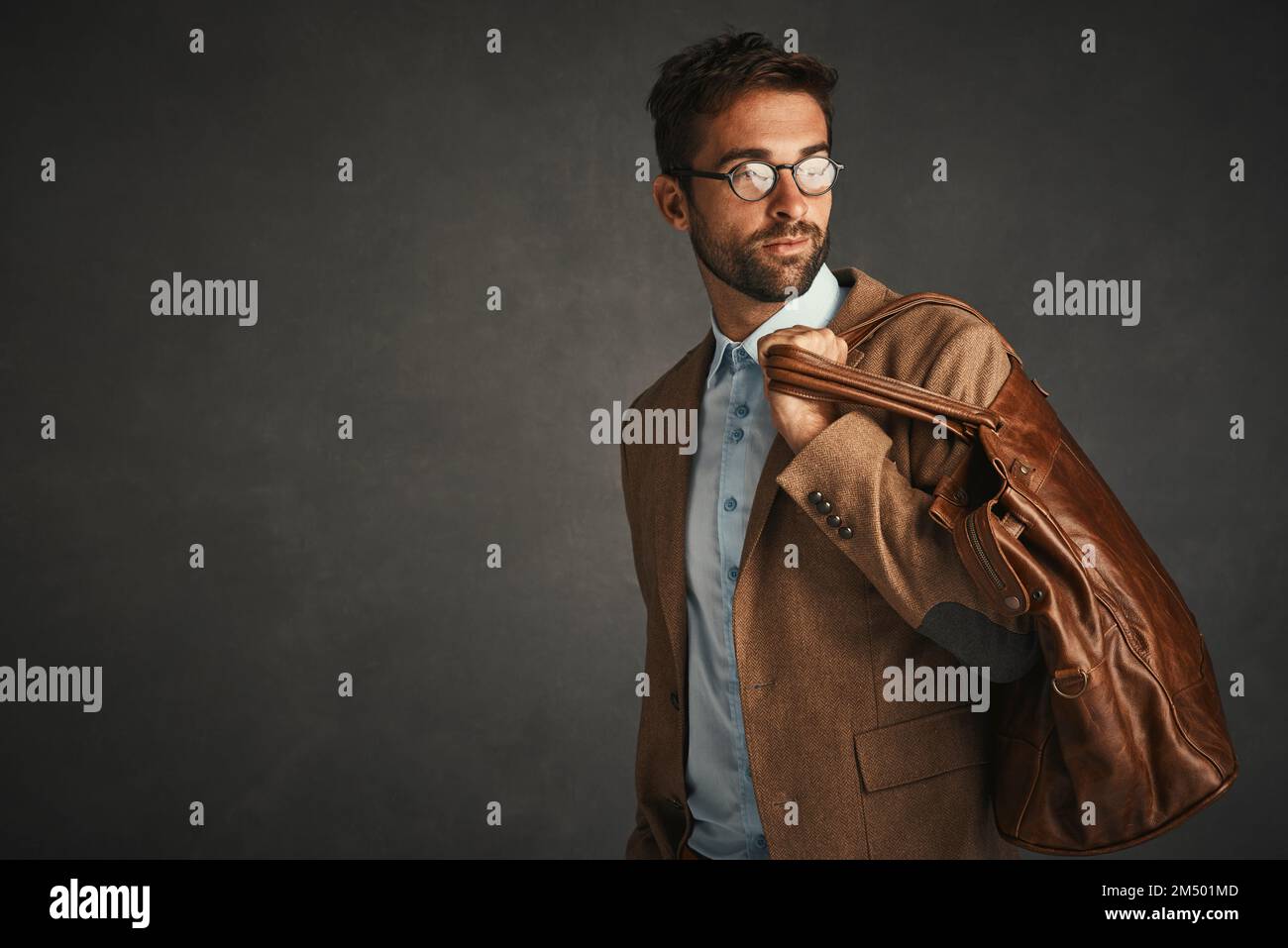 È pronto a andare ovunque con questo abito. Studio di un bel giovane uomo che si posa su uno sfondo grigio. Foto Stock