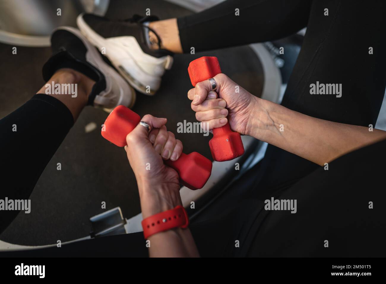Una donna femmina caucasica matura mani sottili tenere manubri durante l'allenamento a casa o centro fitness persone reali stile di vita sano concetto copia spazio t Foto Stock
