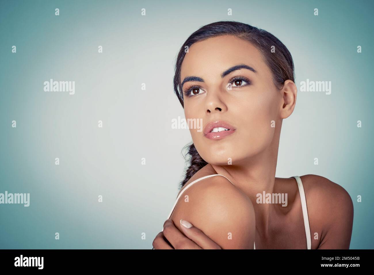 La pelle impeccabile è ciò che mira. Studio di una bella giovane donna che posa su uno sfondo verde. Foto Stock