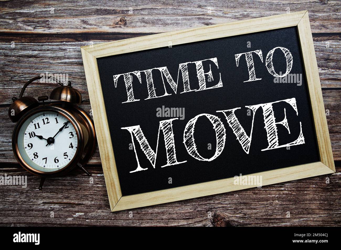 Tempo di spostare la parola con sveglia su sfondo di legno Foto Stock