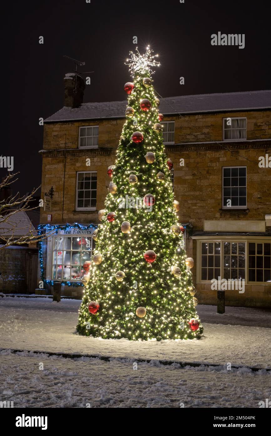 Albero di Natale nella neve di notte. Broadway, Cotswolds, Worcestershire, Inghilterra Foto Stock