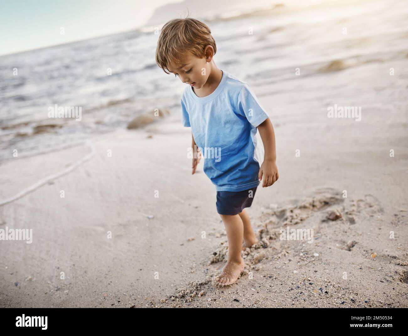 Questo piccolo ama il divertimento sotto il sole. un adorabile ragazzino in spiaggia. Foto Stock