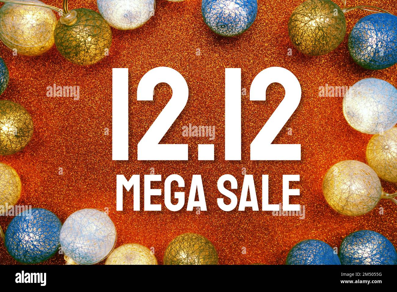 12,12 testo Mega sale e palline in cotone a LED decorazione su sfondo arancione glitter Foto Stock