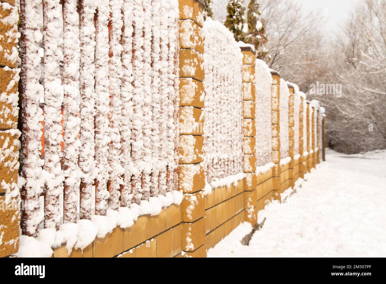 recinzione nella neve in inverno pomeriggio nel parco in una giornata di sole Foto Stock