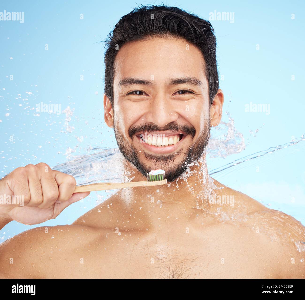 Spruzzi d'acqua, ritratti o denti per l'uomo in studio con spazzolino per denti bianchi o igiene orale. Pulizia di viso, dentifricio o persona felice Foto Stock