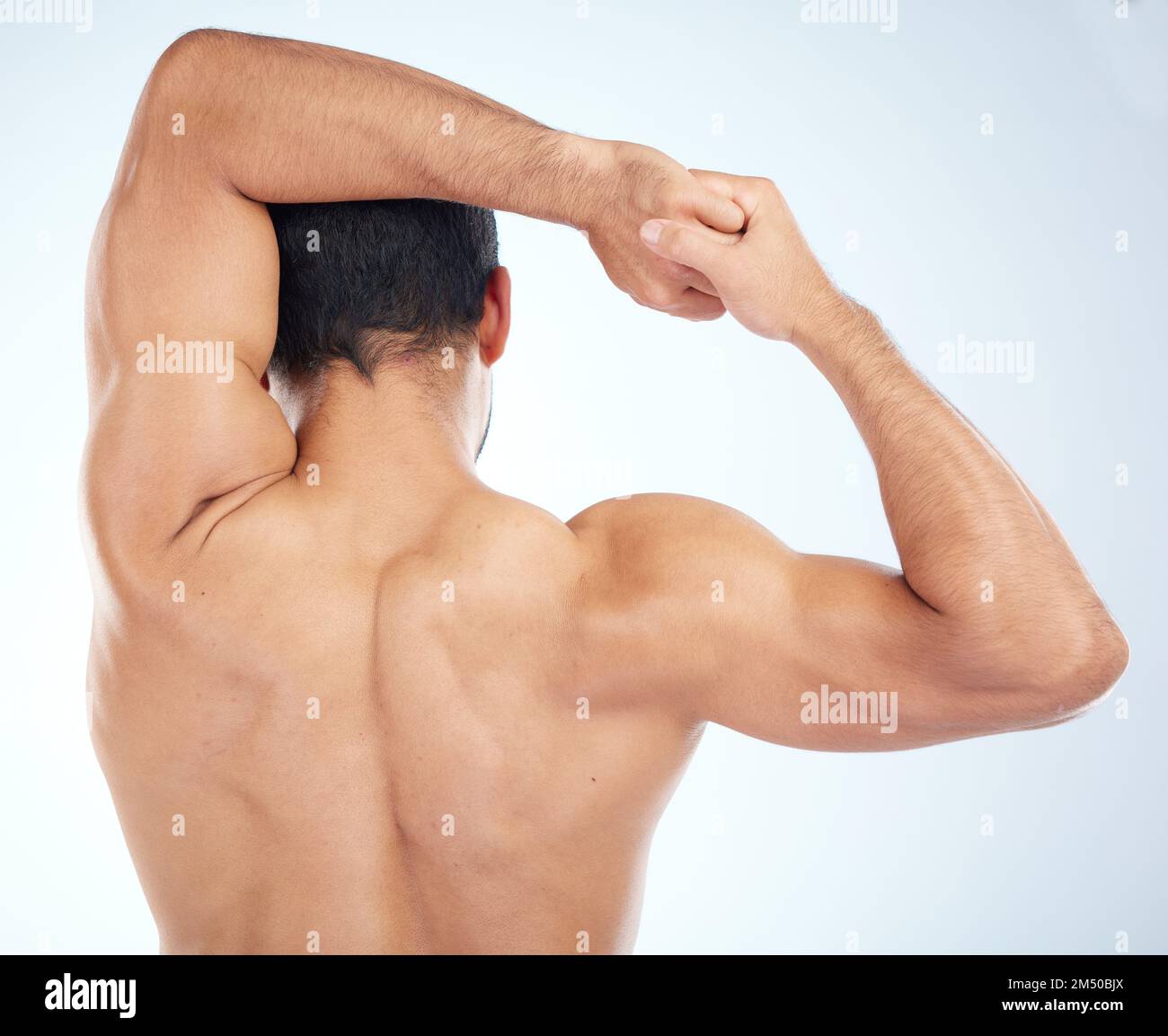 Uomo, fitness stretching e vista posteriore per il benessere muscolare, la cura del corpo e l'esercizio sportivo o riscaldamento in studio. Atleta, braccio estensibile e allestitore Foto Stock
