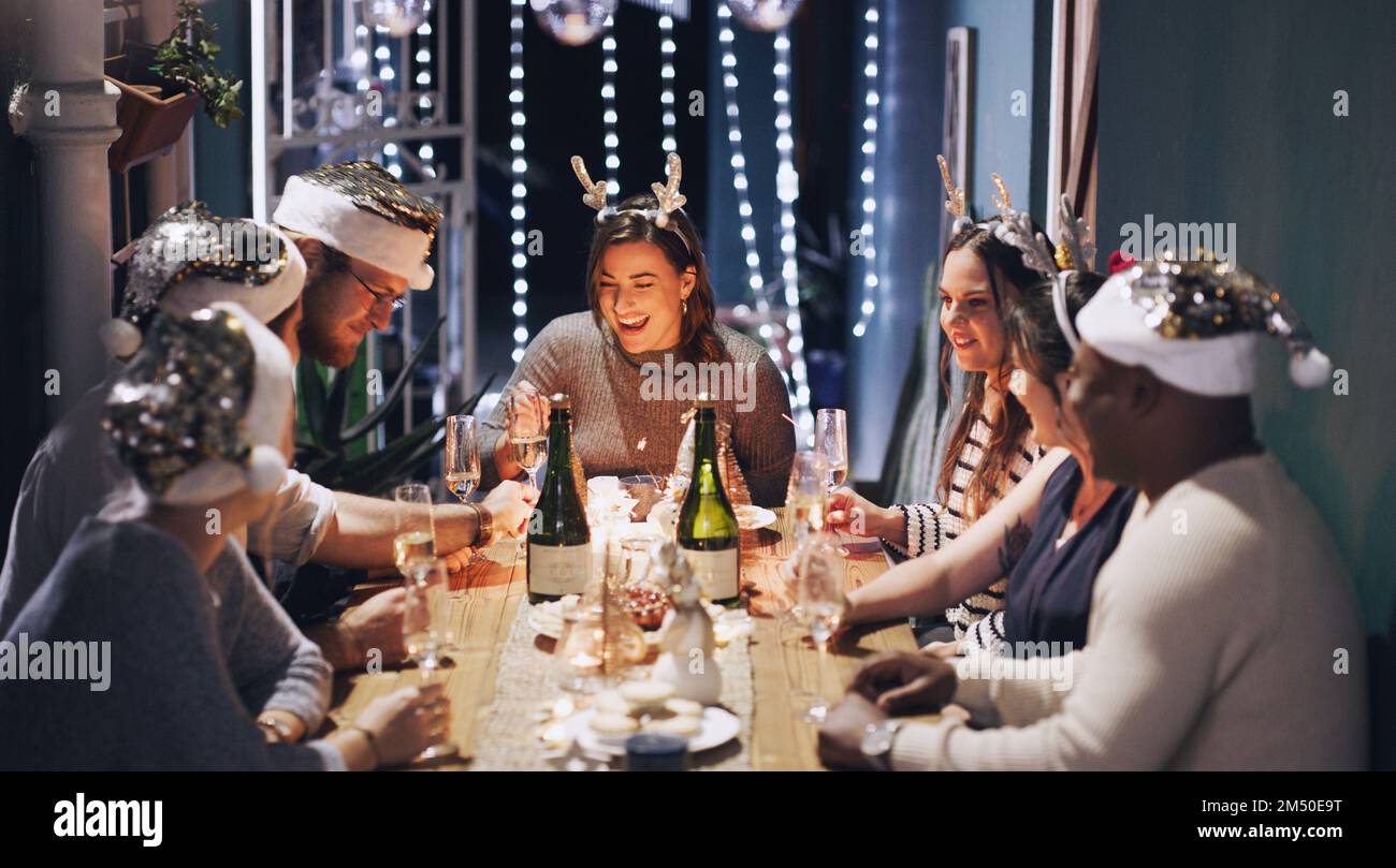 Dicembre fatto a destra. un gruppo di giovani amici che hanno un pasto festivo insieme a casa. Foto Stock