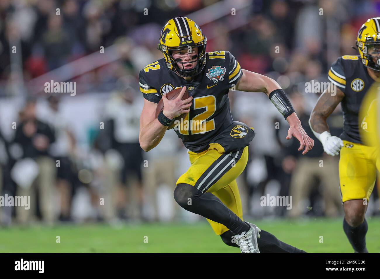 Tampa Bay, FL USA; il quartback Brady Cook delle Tigers del Missouri (12) cattura un attacco errato e recupera la palla e corre e lancia un passaggio di touchdown duri Foto Stock