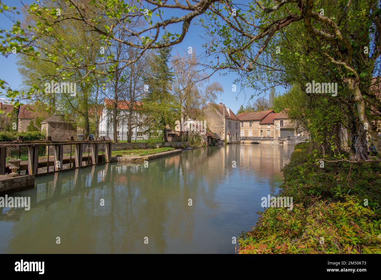 Un canale nella piccola città di Donzy, preso in una giornata di sole primavera in Borgogna, Francia Foto Stock