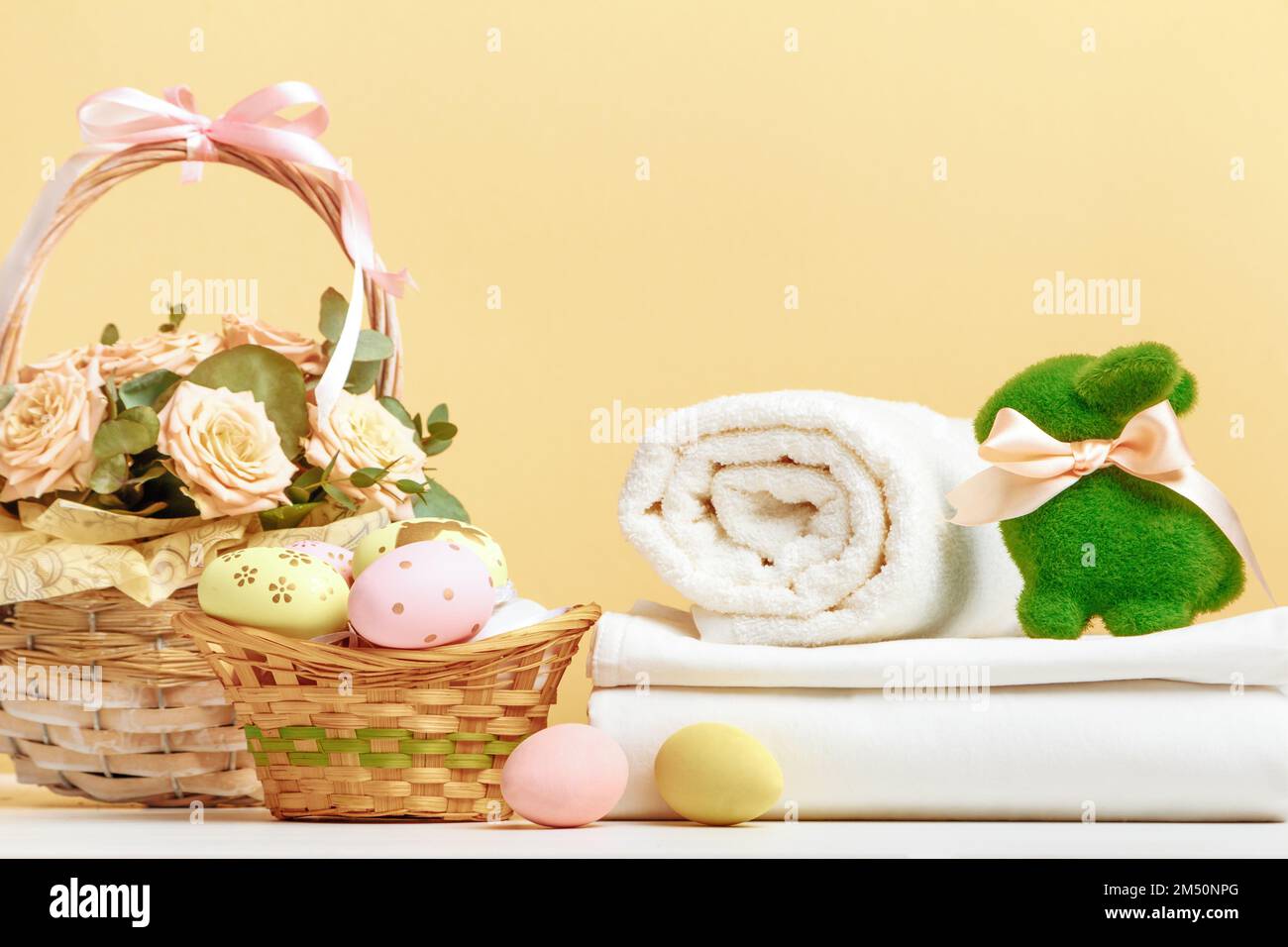 Decorazioni pasquali e una pila di lenzuola bianche e rotoli di asciugamani sul tavolo. Foto Stock