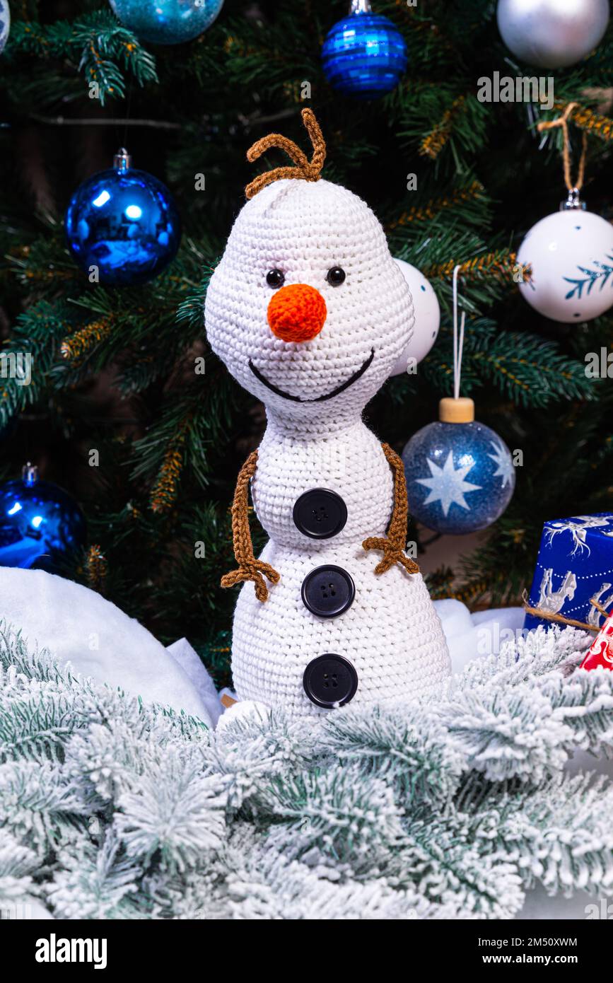 Pupazzi di neve a maglia in cappelli e sciarpe colorati su sfondo blu. Il concetto di Natale, Capodanno e fiaba invernale. Giacitura piatta Foto Stock
