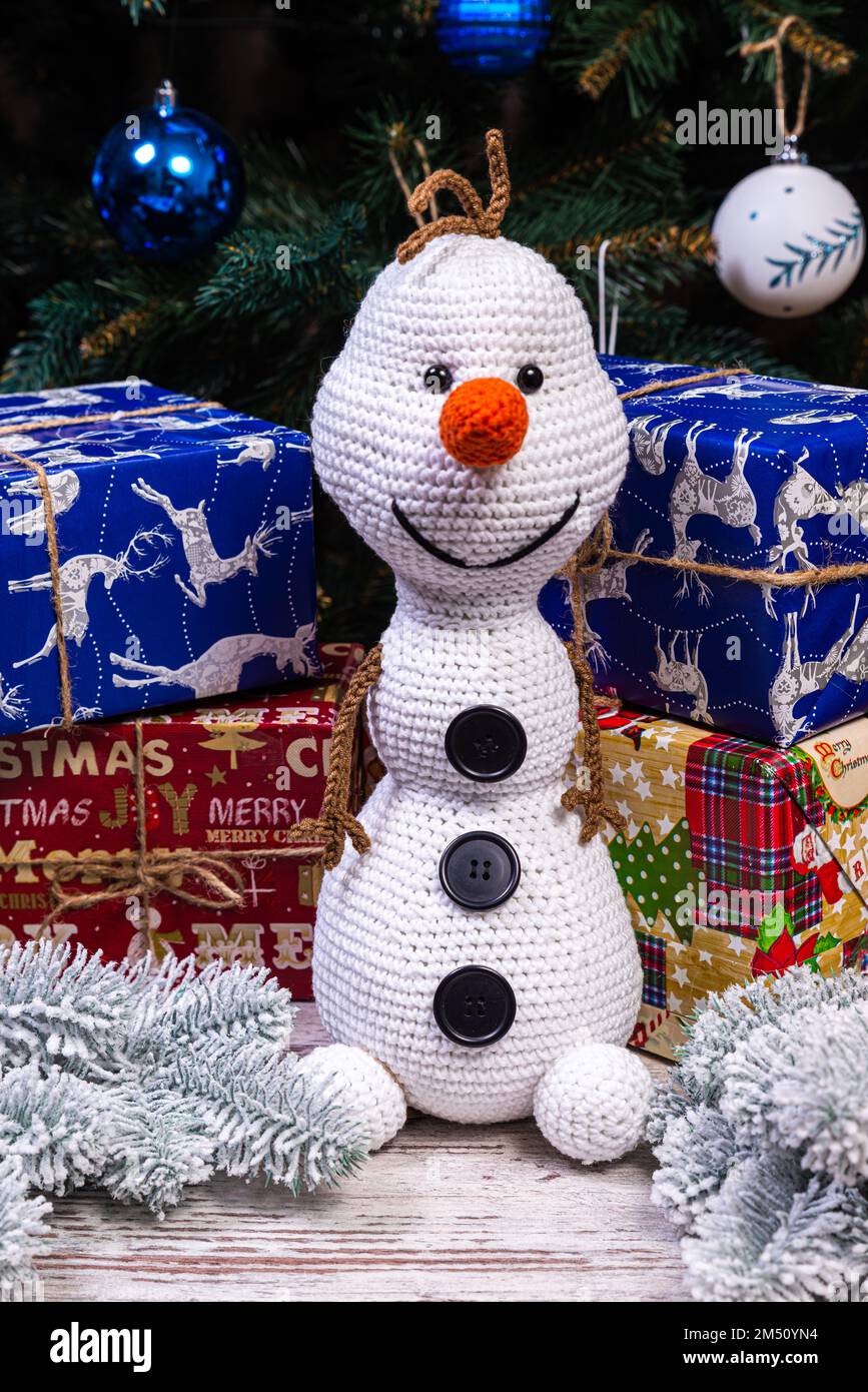 Pupazzi di neve a maglia in cappelli e sciarpe colorati su sfondo blu. Il concetto di Natale, Capodanno e fiaba invernale. Giacitura piatta Foto Stock