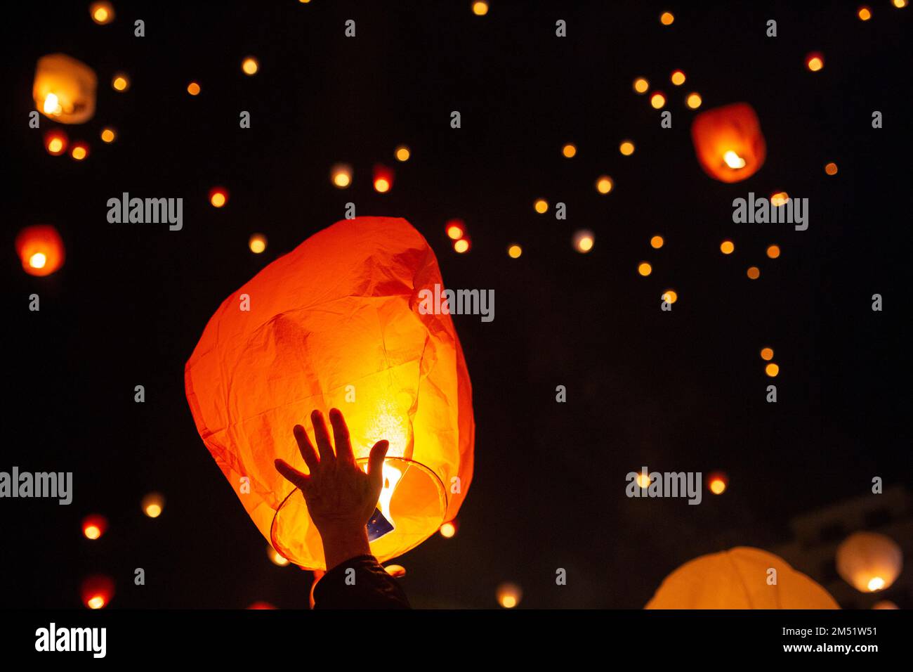 Athen, Grecia. 24th Dec, 2022. Le persone rilasciano le loro lanterne  brucianti nel cielo notturno durante la 'Notte dei desideri' organizzata  dal comune di Atene in Piazza Kotzia. Il calore della fiamma
