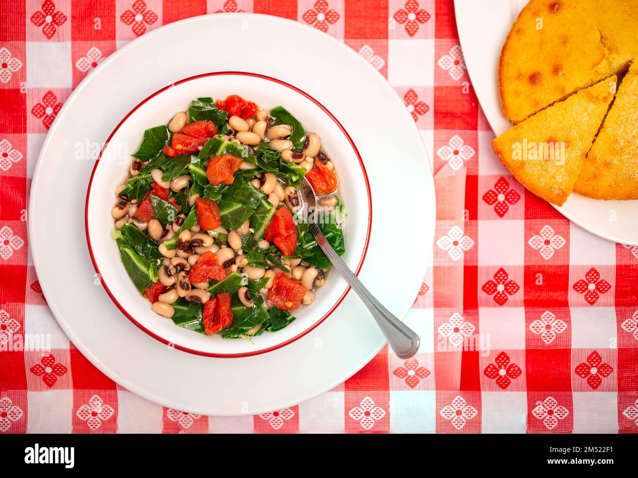 Vista dall'alto della tradizione americana del sud, con piselli neri e verdi da collezione in un recipiente bianco con pane di mais; spazio copia Foto Stock