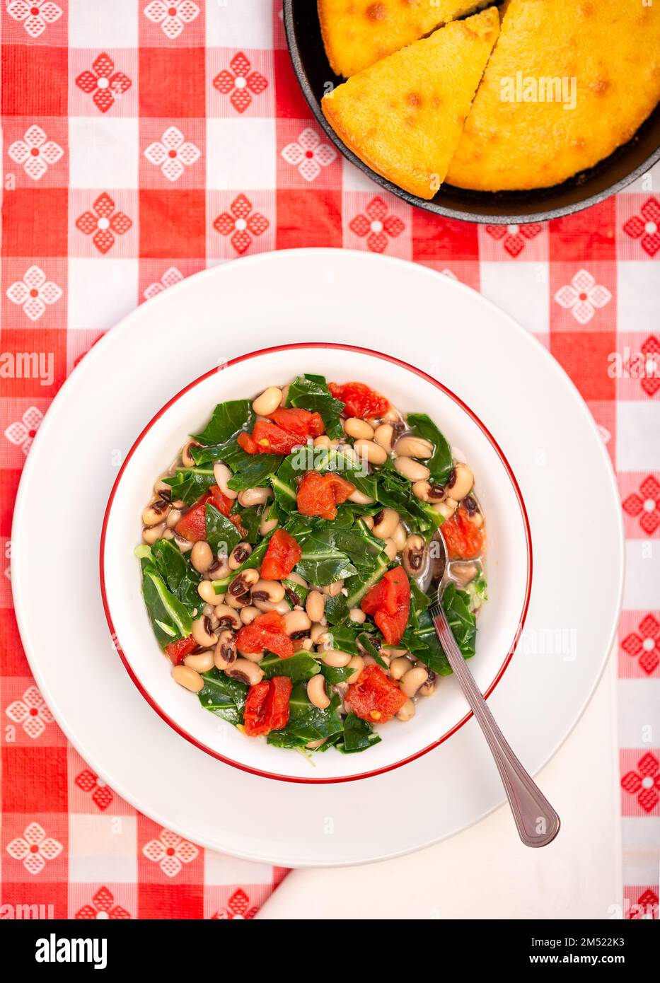 Vista dall'alto della tradizione americana del sud, con piselli neri e verdi da collezione in un recipiente bianco con pane di mais; spazio copia Foto Stock