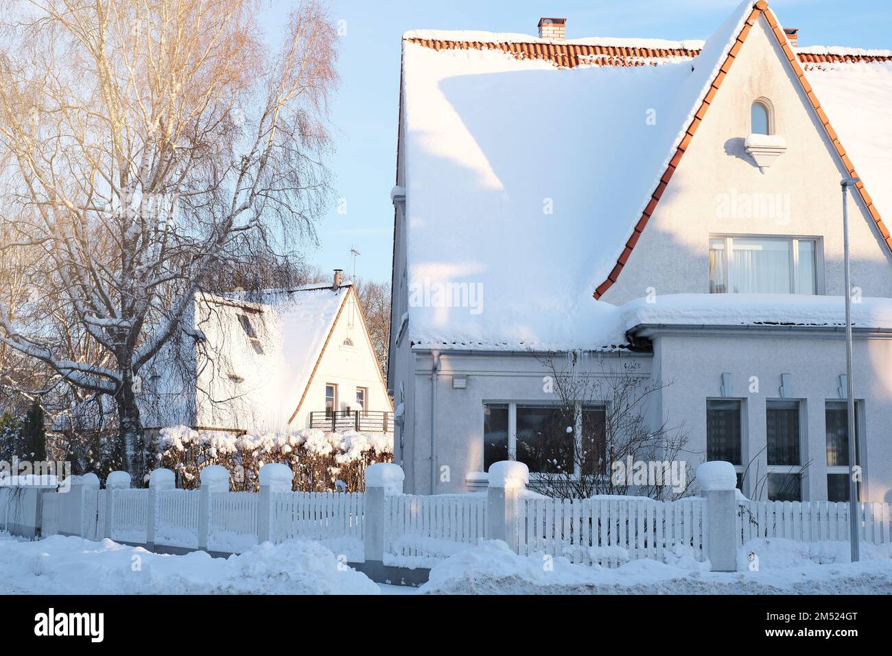 Paesaggio fiabesco invernale sulla strada con case con un tetto triangolare e strade ricoperte di molta neve Foto Stock