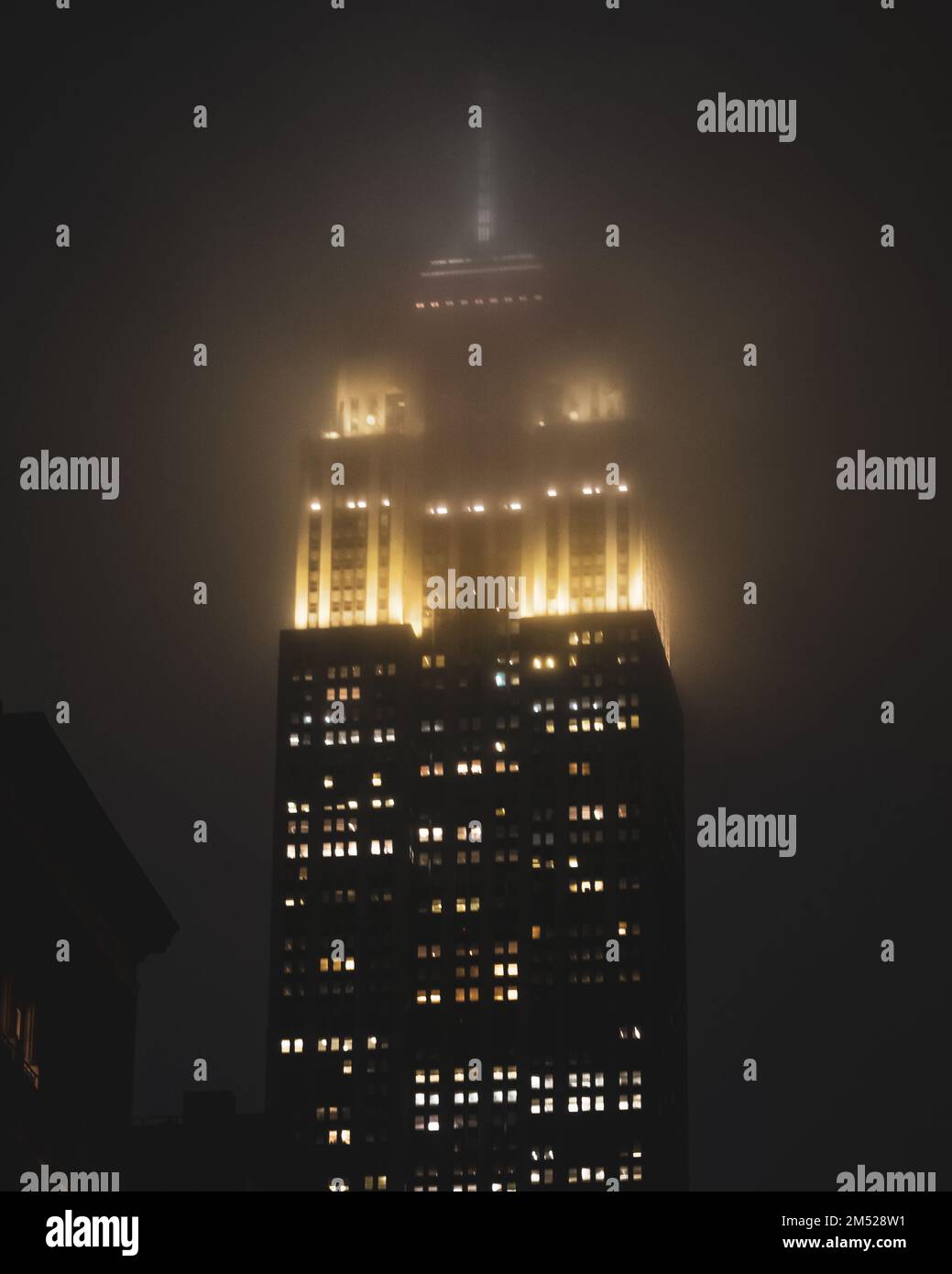Una vista dall'alto dell'Empire state Building a NYC durante una notte di nebbia Foto Stock